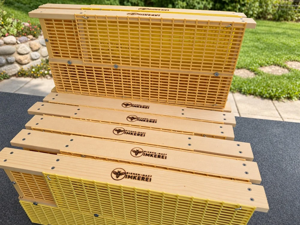 Bannwabenkäfige aus Holz mit gelben Absperrgittern und eingebranntem Bienen-Naef-Logo
